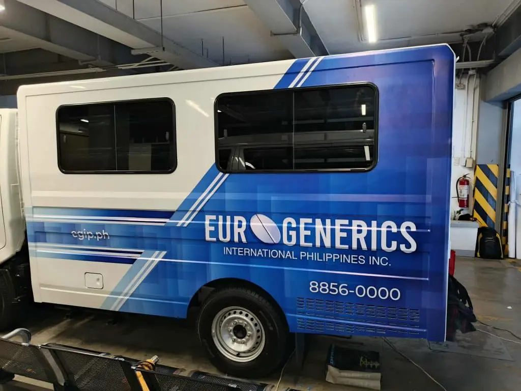 Indoor signage display for Euro Generics International Philippines Inc. in Makati beside branded delivery vehicle by M&G Global Ads.