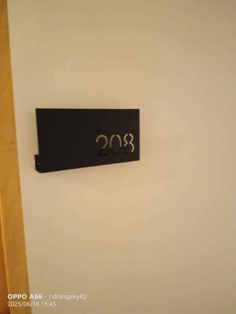 Room number signage 208 in black metal on white wall, wooden door frame, Mandaluyong project by M&G Global Ads.