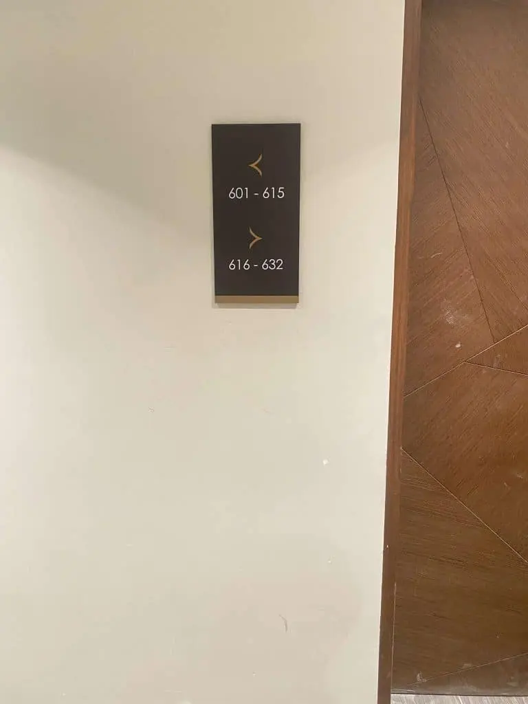 Hotel room directional indoor metallic signage in Mandaluyong, showing arrows for rooms 601–632. Wooden door right. by M&G Global Ads.