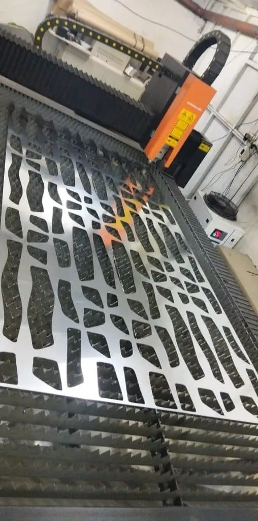 Laser cutting machine creates abstract custom indoor signage for offices in Makati, with tools visible. by M&G Global Ads.