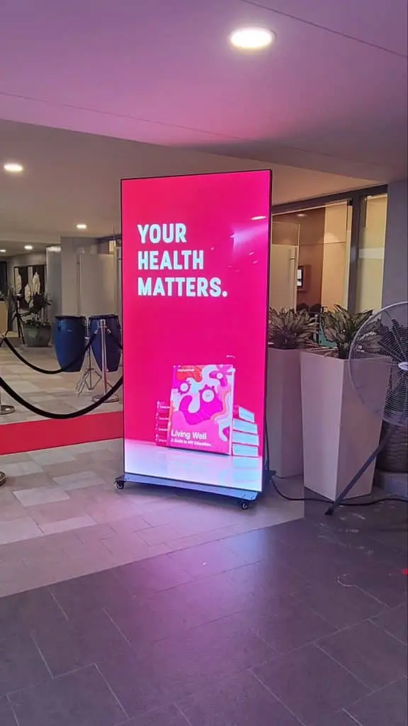Digital signage in a building lobby, Ortigas, shows YOUR HEALTH MATTERS. with books; by M&G Global Ads.