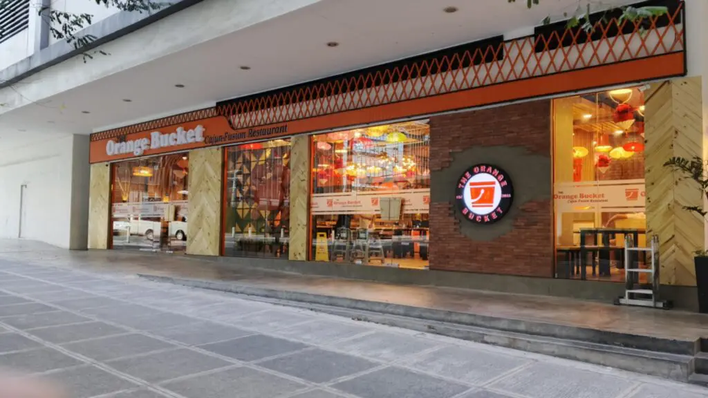 Orange Bucket seafood restaurant with outdoor round LED acrylic signage and orange decor, Metro Manila, sign maker Philippines by M&G Global Ads.