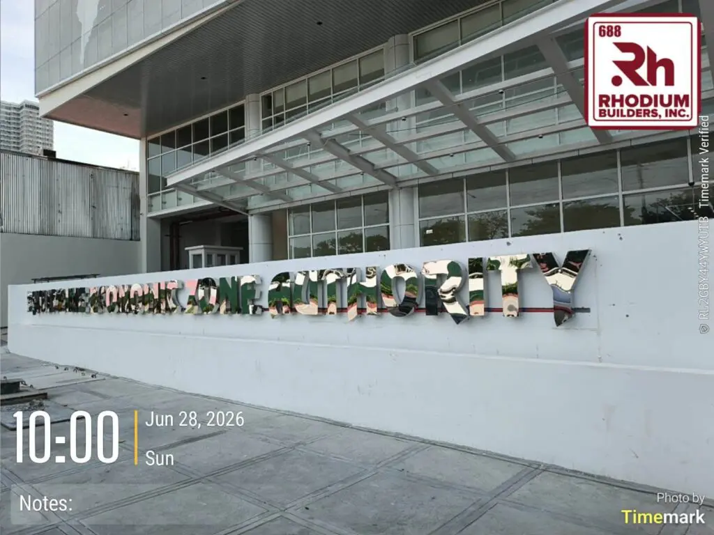 Acrylic building signage with mirrored letters on a white background displaying "Science Authority," featuring overlaid date and time info and logos for Rhodium Builders, Inc. and Timemark, located in the Philippines. Sign maker Philippines by M&G Global Ads.