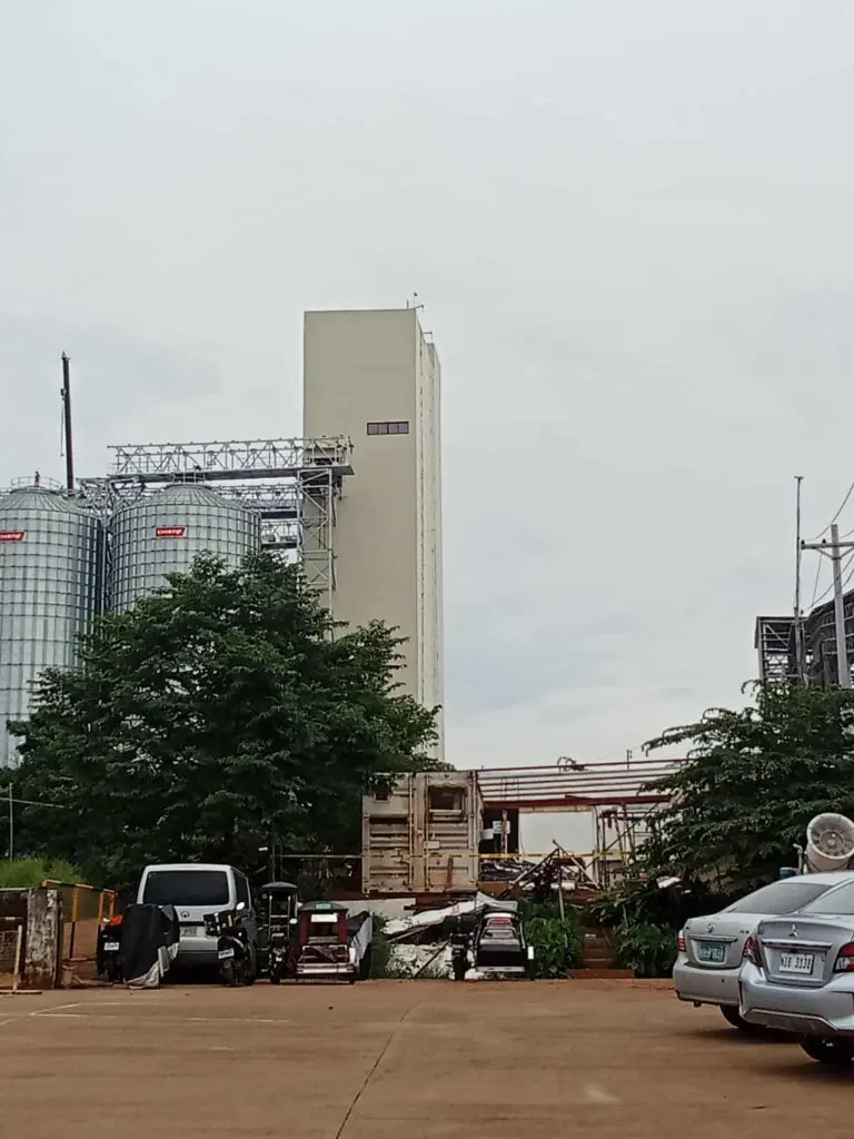 Industrial building with aluminum outdoor building signage, silos, trees, parking; sign maker Philippines by M&G Global Ads.