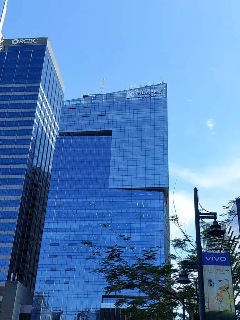Building signage with RCBC and Pioneer acrylic/LED logos on tall glass offices, Metro Manila, sign maker Philippines by M&G Global Ads.