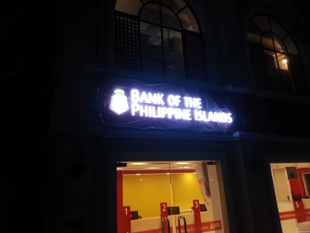 Illuminated Bank of the Philippine Islands storefront signage in Makati at night with red accents, by M&G Global Ads.