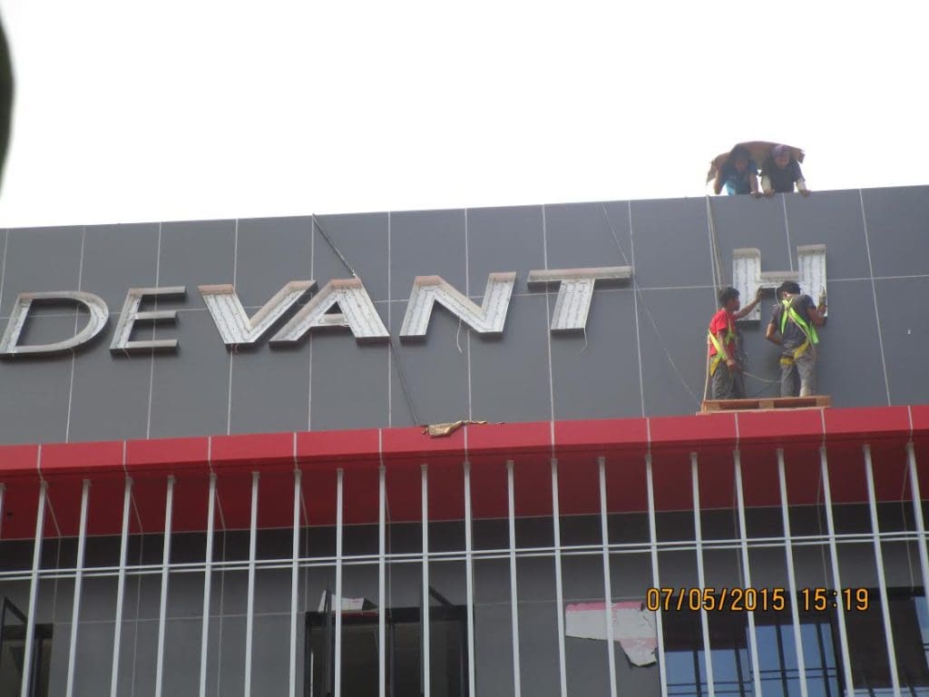 LED building signage installation for DEVANT by workers in safety gear, Makati location, red awning—by M&G Global Ads.
