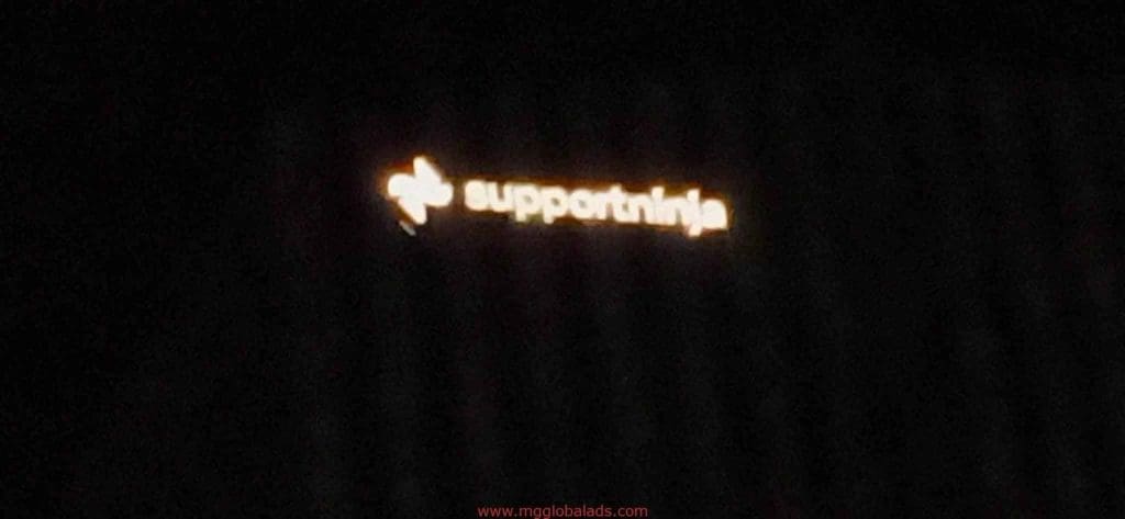 Blurry LED signage for SupportNinja with glowing logo and text on a dark background in Makati by M&G Global Ads.