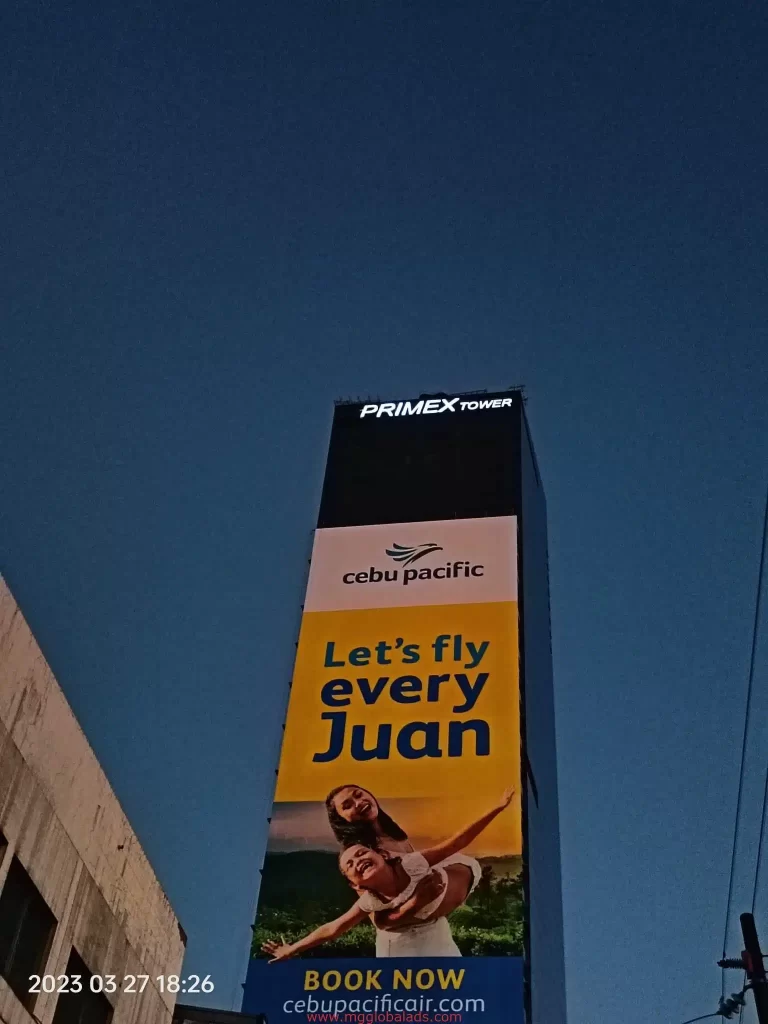 Cebu Pacific billboard signage on Primex Tower in Ortigas, features playful two people and slogan Lets fly every Juan by M&G Global Ads.