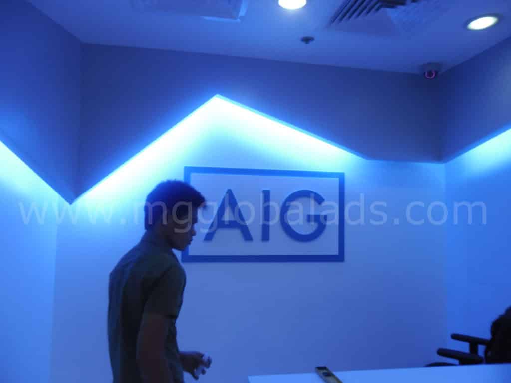 AIG LED signage with blue lighting in a modern Makati office, featuring chairs and white table, by M&G Global Ads.