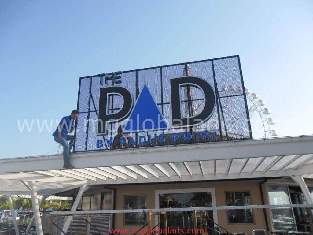 Large LED signage for THE PAD BY PADS POINT in Makati with Ferris wheel in background, rooftop view by M&G Global Ads.