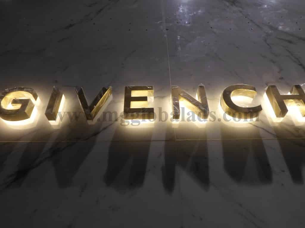 Illuminated gold metal 3D building signage for GIVENCHY on marble wall in Makati, by M&G Global Ads.