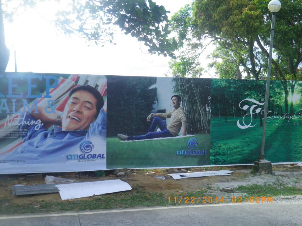 Billboard signage for CitiGlobal Realty featuring a smiling man, displayed outdoors along a Quezon City sidewalk by M&G Global Ads.