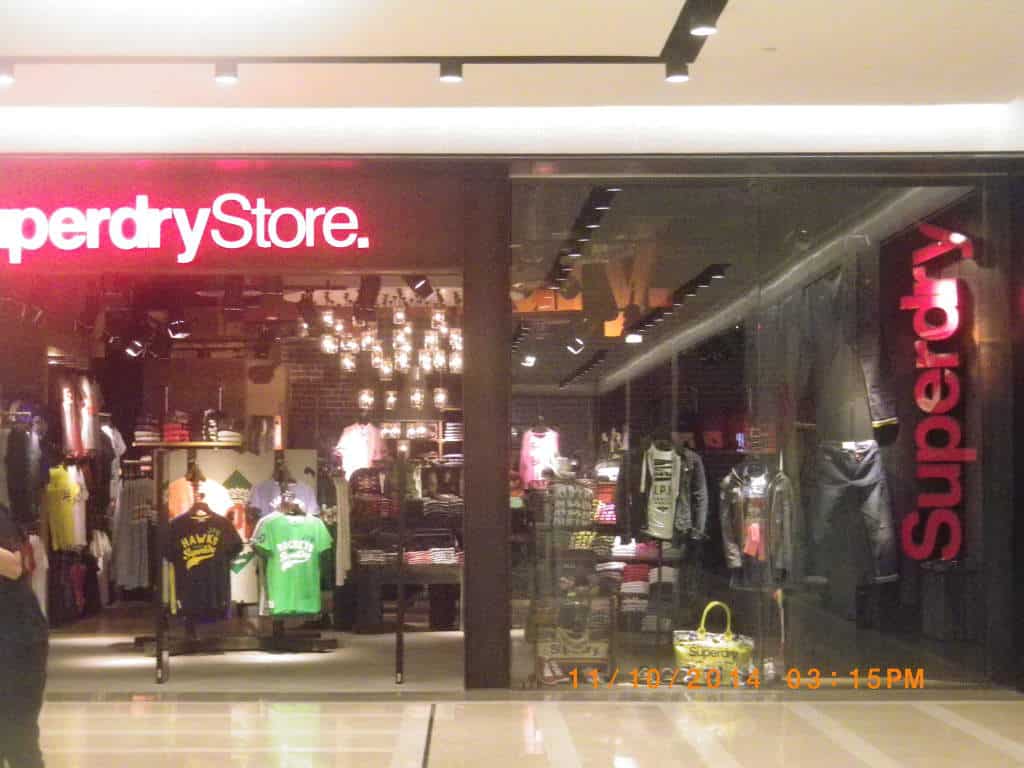 Superdry LED signage at a Makati mall, trendy t-shirts and jackets on display racks and mannequins by M&G Global Ads.
