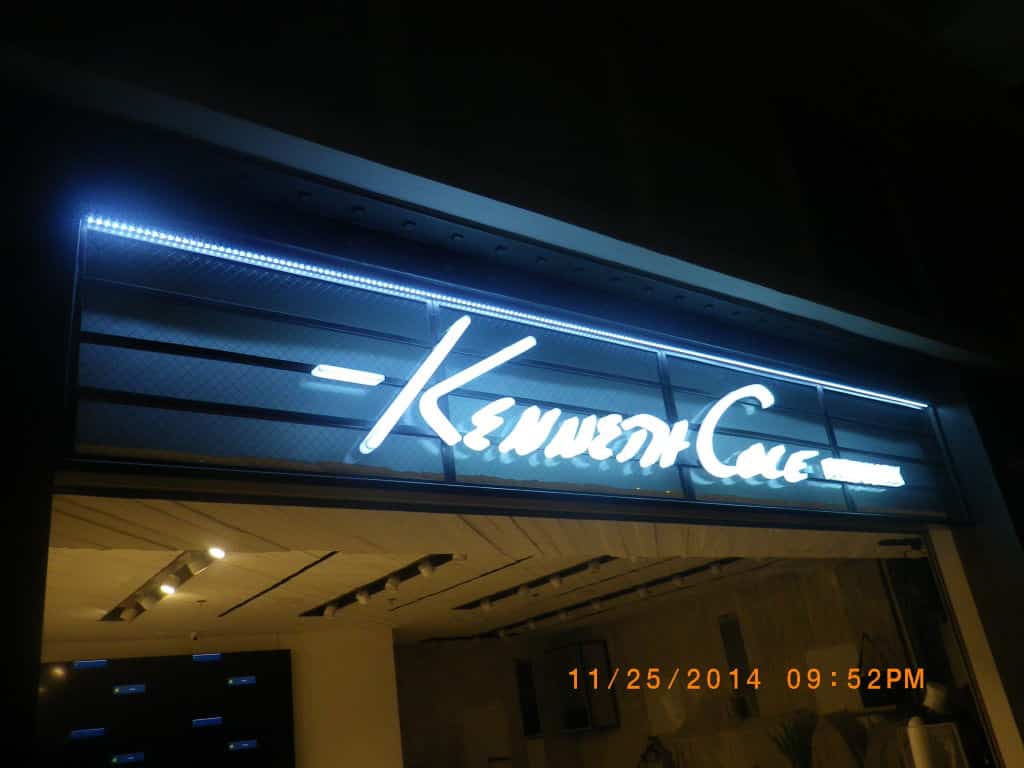 Kenneth Cole LED signage with white illuminated text at night in Makati, store interior visible. By M&G Global Ads.