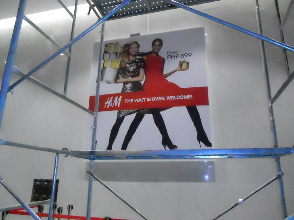 H&M indoor signage, promotional dress ad at a mall in Makati, features two models and sale text; by M&G Global Ads.