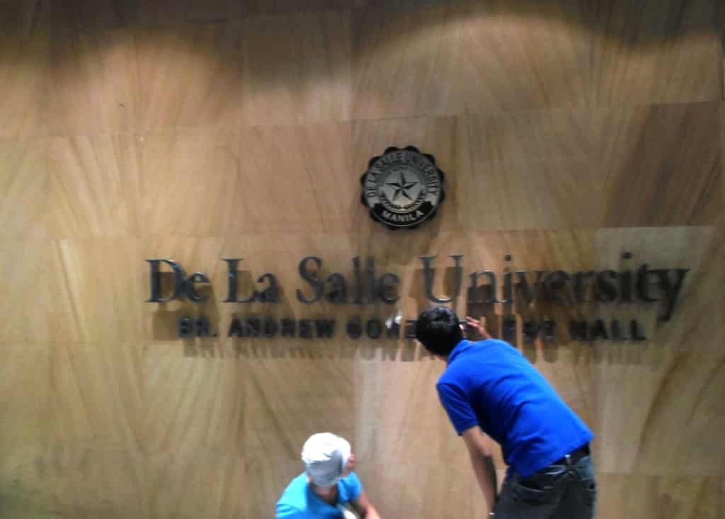 De La Salle University indoor acrylic signage installation in Quezon City, featuring Br. Andrew Gonzales Hall by M&G Global Ads.
