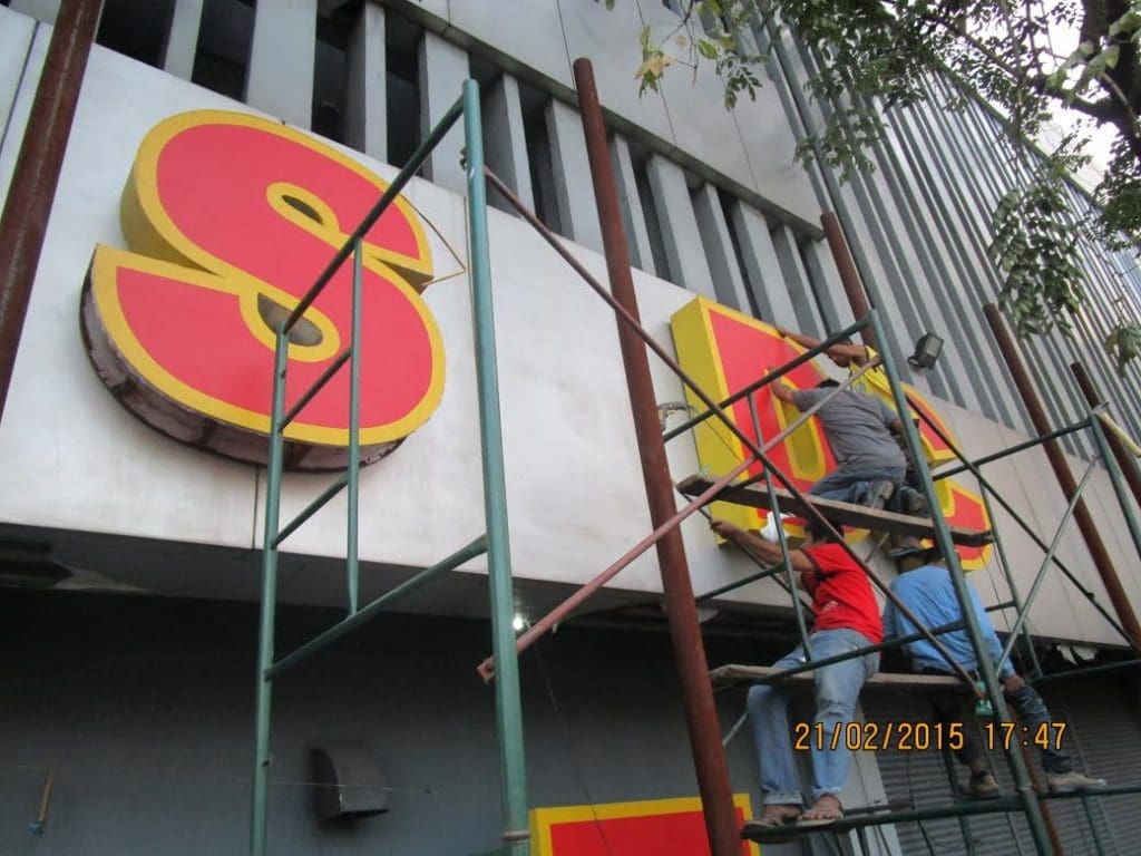 LED channel letter signage installation by workers on scaffolding in Quezon City, building facade, by M&G Global Ads.