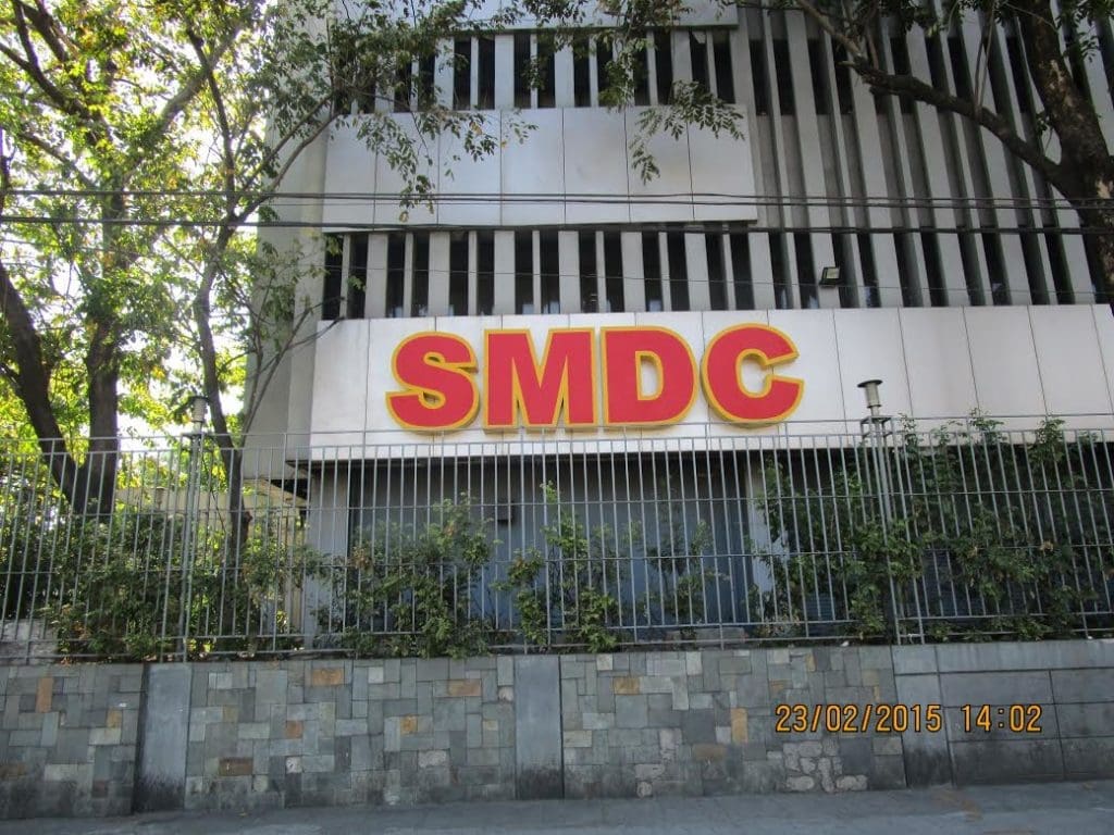 SMDC outdoor building signage in bold yellow and red, Quezon City location, by M&G Global Ads.