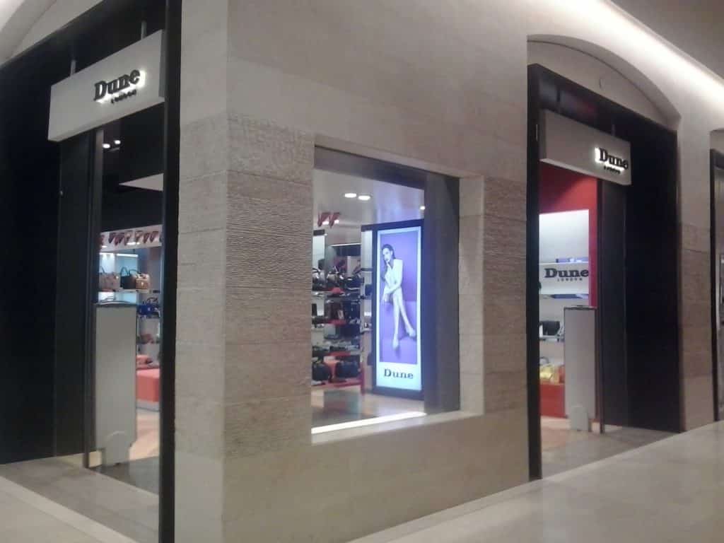Dune London illuminated building signage at mall entrance in Makati, large ad and window display viewed, by M&G Global Ads.