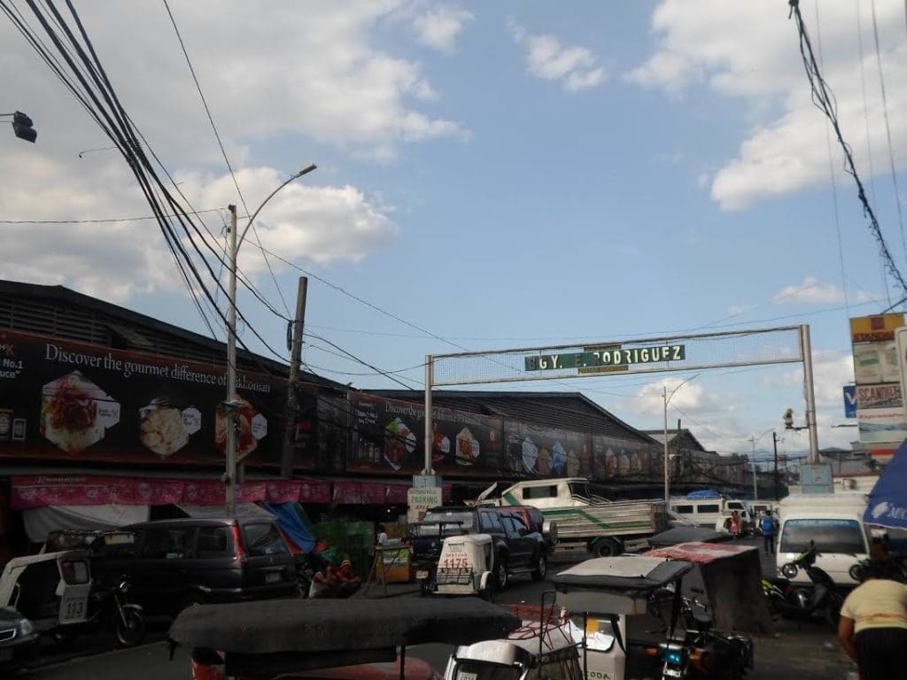 C.Y. RODRIGUEZ building signage at a busy market street with ads in Quezon City by M&G Global Ads.