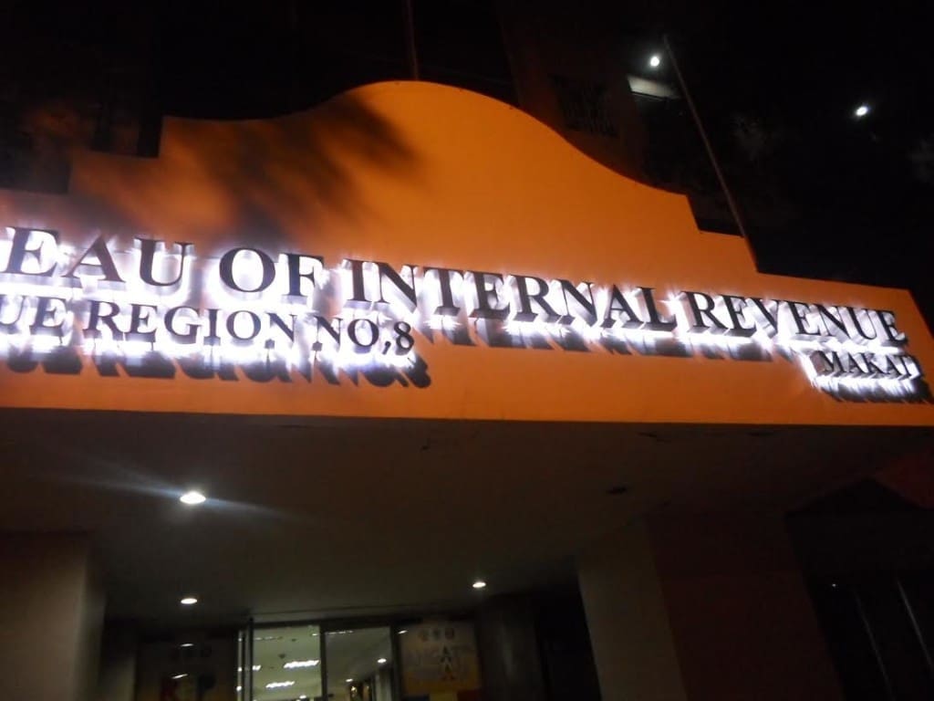 Metallic office signage Bureau of Internal Revenue, Region No. 8 at night in Makati with glare on letters by M&G Global Ads.