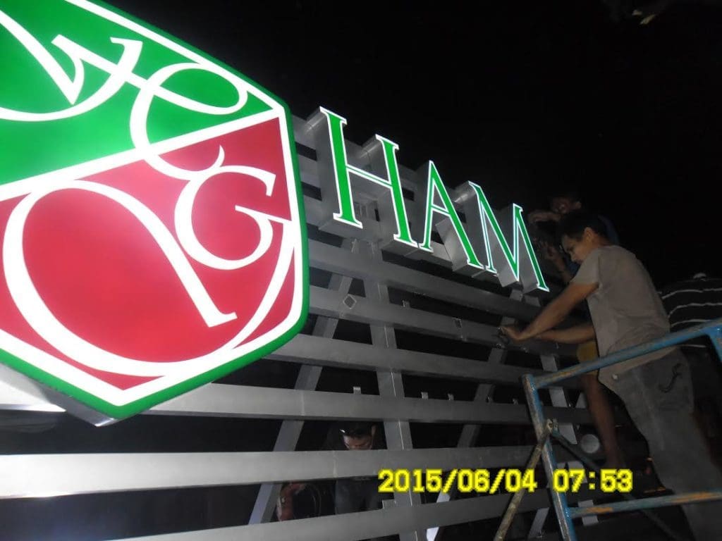 Illuminated building signage installation for HAM with shield logo at night in Makati, by M&G Global Ads.