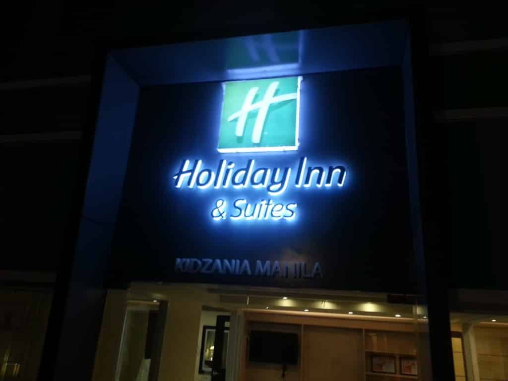 LED indoor signage for Holiday Inn & Suites KidZania Manila in Ortigas, green logo visible at night, by M&G Global Ads.