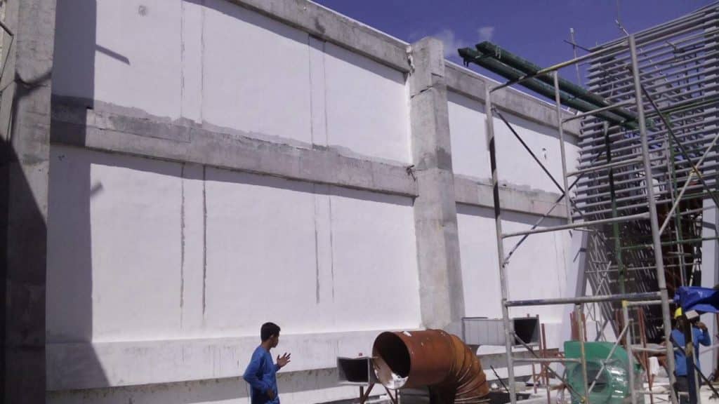 Billboard installation with outdoor signage in Makati; person in blue shirt, scaffolding, beams, clear sky by M&G Global Ads.