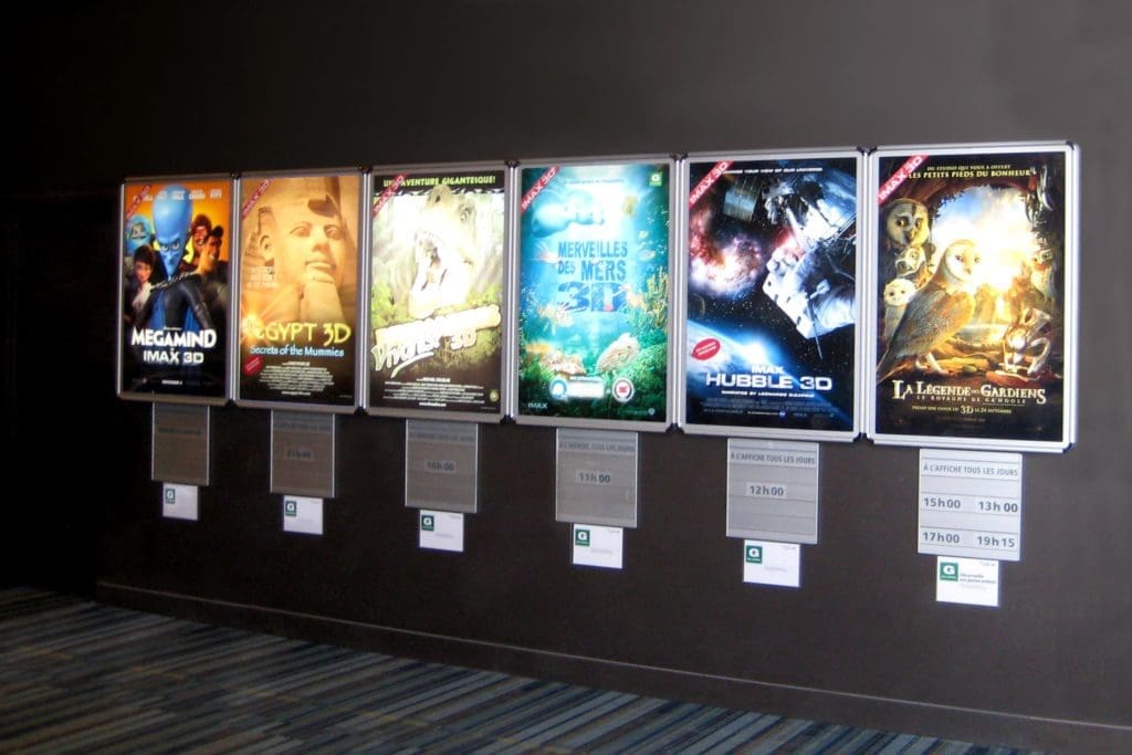 Sleek acrylic cinema signage featuring movie posters and ticket machines at a Makati theater by M&G Global Ads.