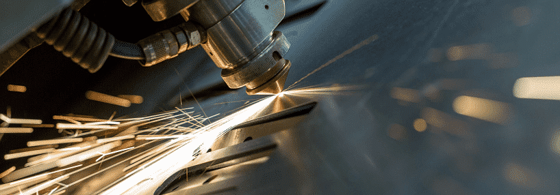 Laser cutting machine close-up with sparks, ideal for metal indoor signage in Ortigas by M&G Global Ads.