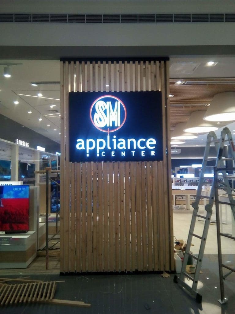 Illuminated metallic SM Appliance Center signage at store display in Makati, installation setup by M&G Global Ads.