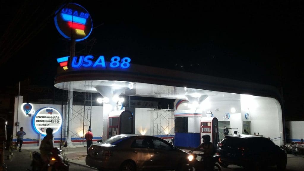 USA 88 gas station metallic illuminated signage with cars and bikes at night in Quezon City, by M&G Global Ads.