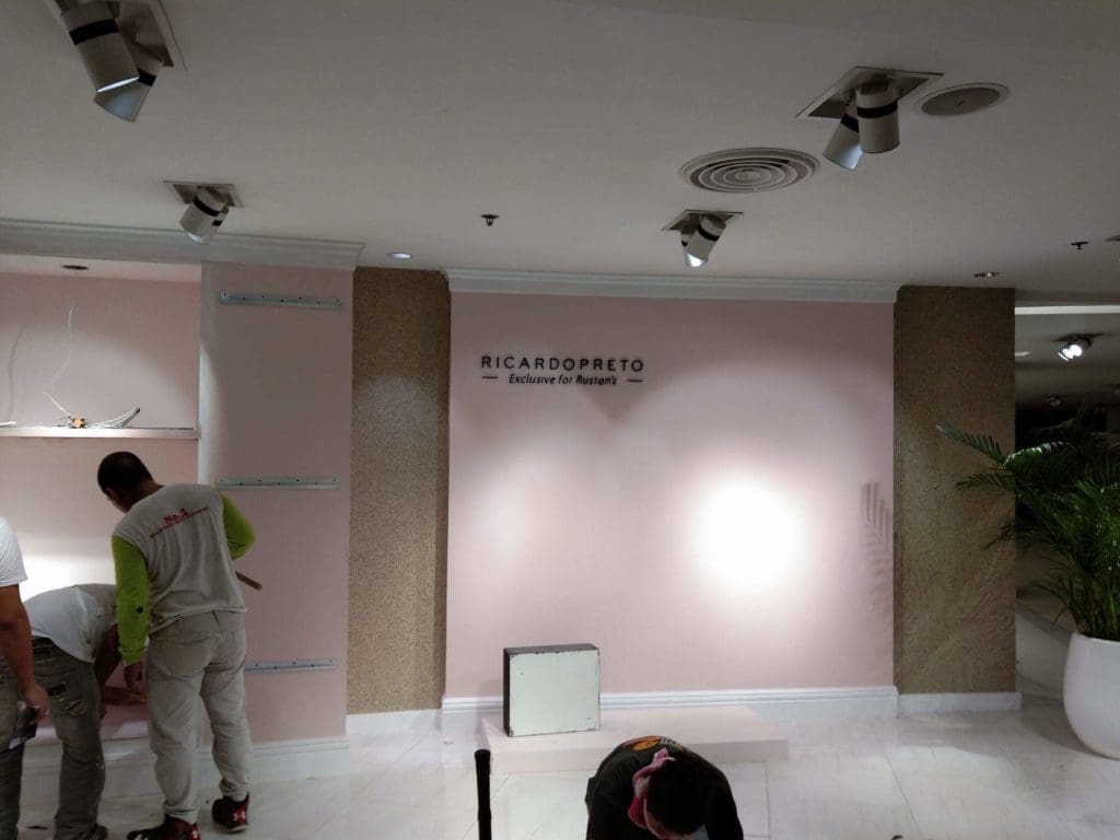 Metallic store signage for Rustan’s client installed in Makati, with workers and tools visible. By M&G Global Ads.