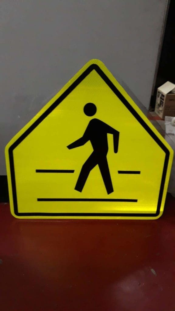 Pedestrian crossing warning signage, yellow reflective metal, seen in Makati, by M&G Global Ads.