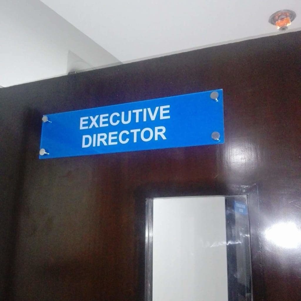 Office door signage EXECUTIVE DIRECTOR on blue acrylic, mounted in Ortigas office interior, by M&G Global Ads.