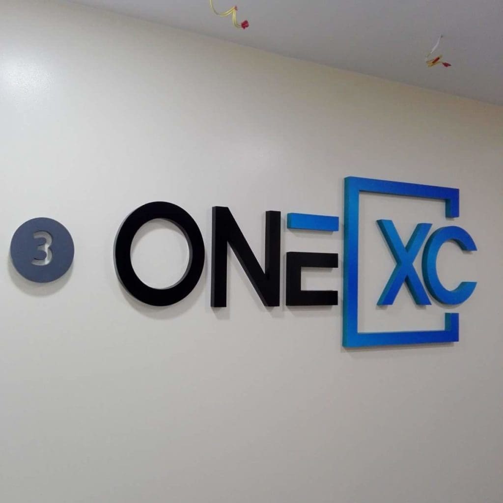 Outdoor pylon signage with number 3 in gray circle, ONE XC logo, blue frame; Ortigas location by M&G Global Ads.