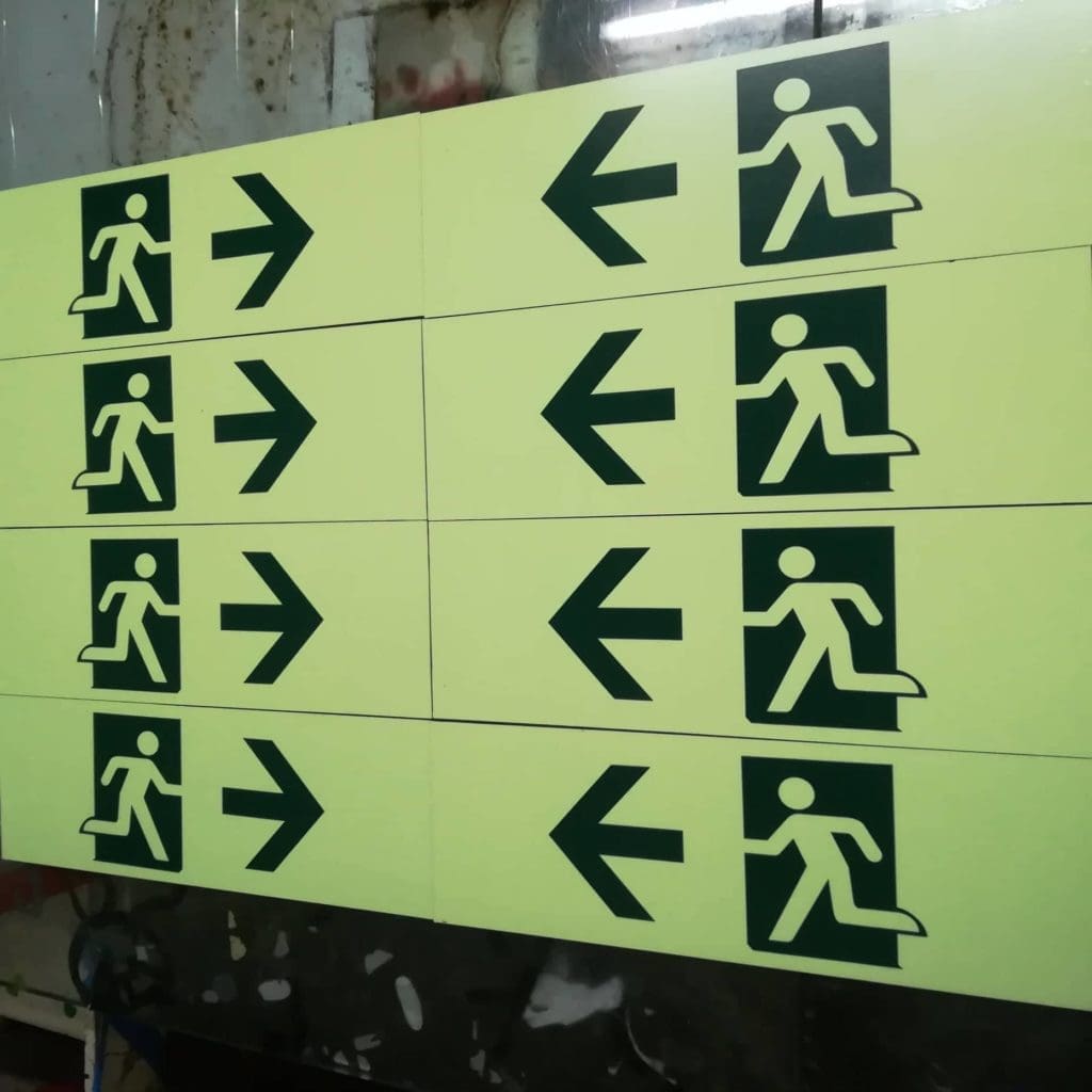 Metallic emergency exit signs set with left-pointing arrows, yellow background, in Makati by M&G Global Ads.