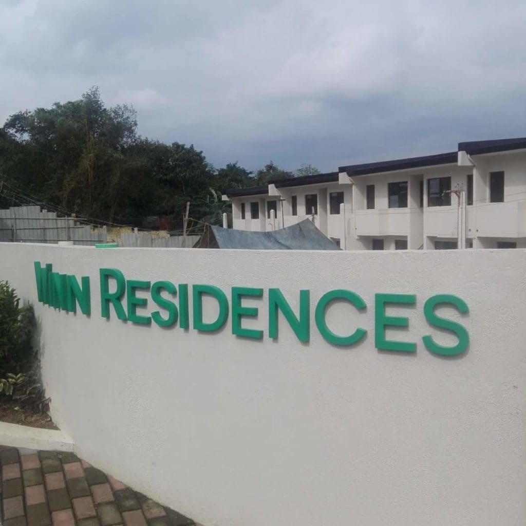 Green outdoor building signage MAIN RESIDENCES in front of modern condo, Mandaluyong. Outdoor signage by M&G Global Ads.