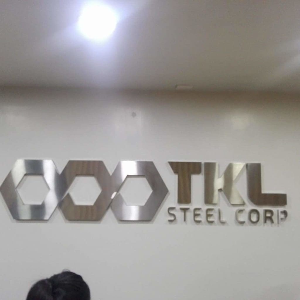 Metallic office signage for TKL STEEL CORP in Makati, with hexagon logo detail, wall-mounted indoors by M&G Global Ads.