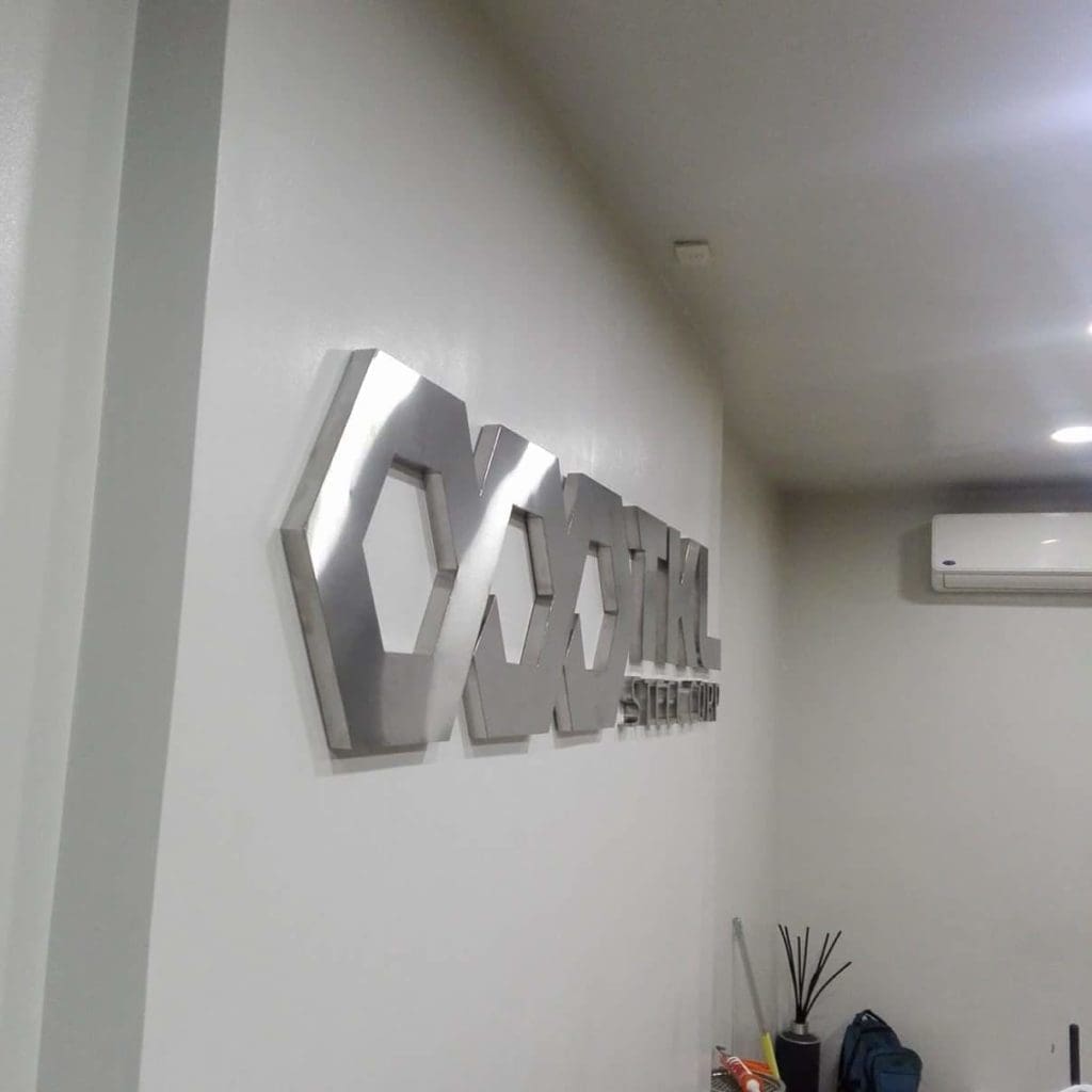 3D acrylic office signage with geometric shapes and OPTICAL lettering in Makati, modern white wall decor by M&G Global Ads.