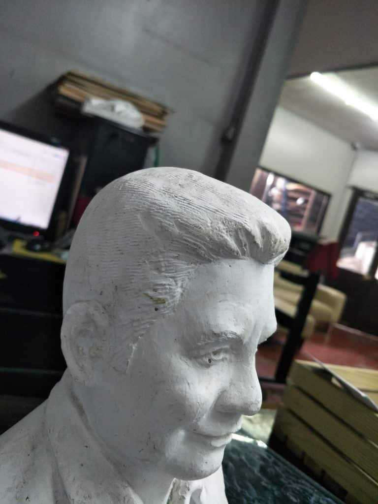 Metallic office signage in Makati with computers and decor, white plaster bust on table. By M&G Global Ads.