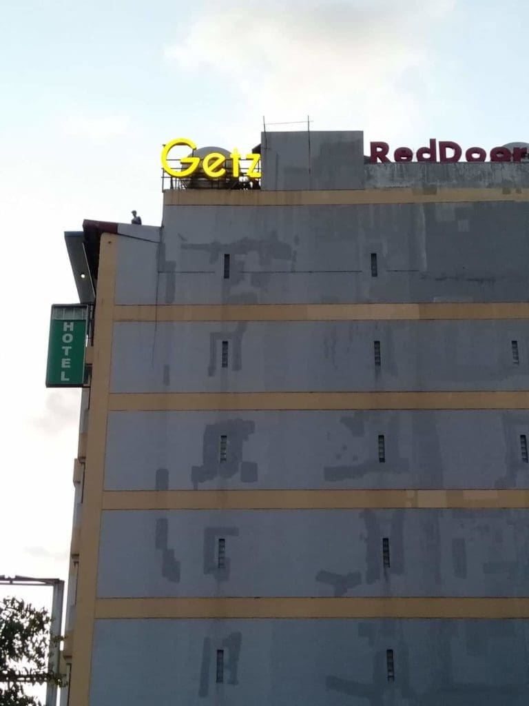 Hotel building signage for Getz Hotel with a green vertical HOTEL sign in Cubao by M&G Global Ads.