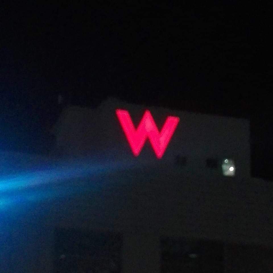 LED building signage with large red W at night in Makati, bright against dark sky, by M&G Global Ads.