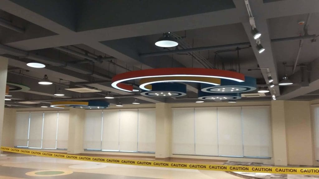 Acrylic signage in a modern spacious room with circular ceiling lights and exposed pipes, Makati office by M&G Global Ads.