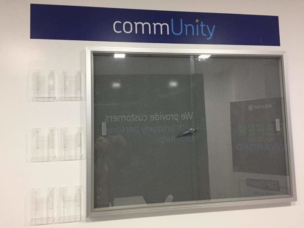 Metallic commUnity wall signage with brochure holders in a white Ortigas office interior by M&G Global Ads.