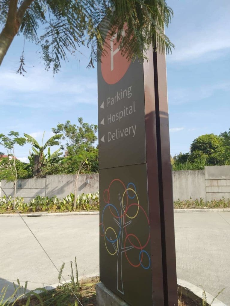 Metallic wayfinding signage for hospital parking and delivery, Ortigas location, with abstract tree art by M&G Global Ads.