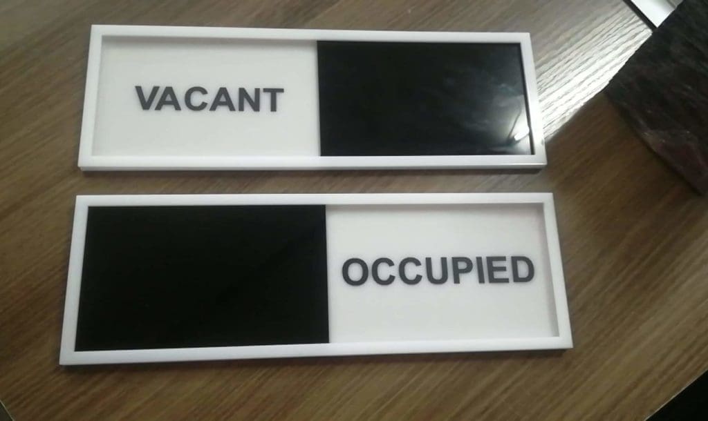 Office door signage in Makati: metallic VACANT sign with white background, OCCUPIED sign half-covered in black by M&G Global Ads.