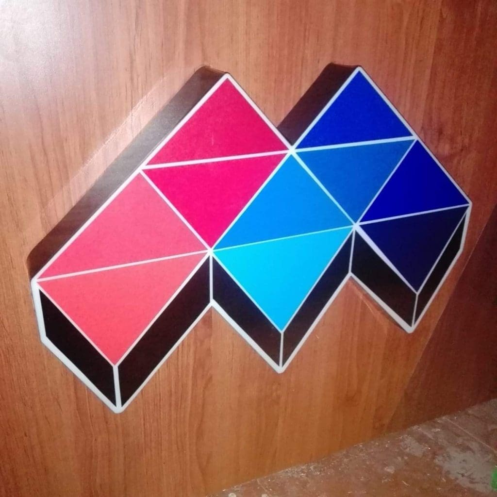 3D cube effect wall signage with red and blue triangles on wood in Mandaluyong, metallic style by M&G Global Ads.