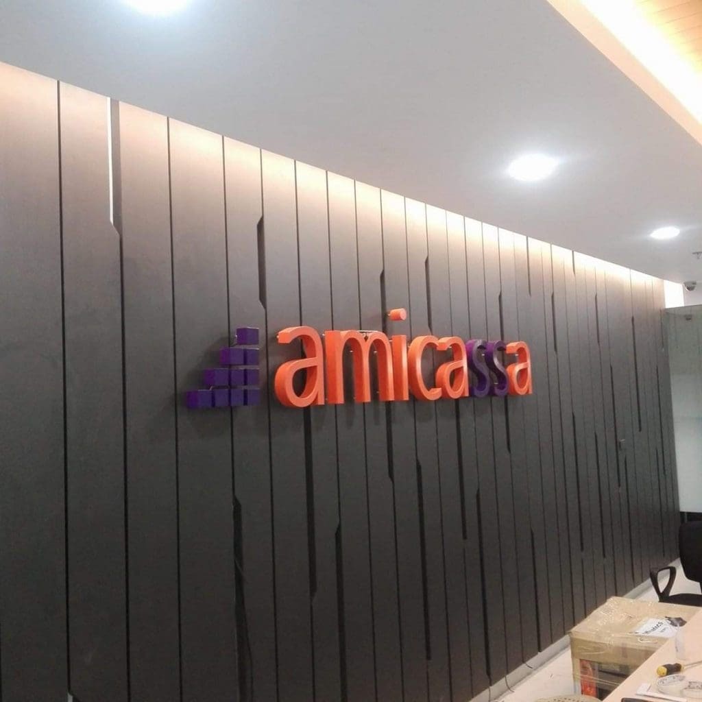 Amicassa 3D office indoor signage on dark wall panels in Makati, with ceiling lights and counter, by M&G Global Ads.